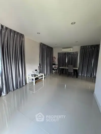Spacious living room with modern decor and large windows for natural light.