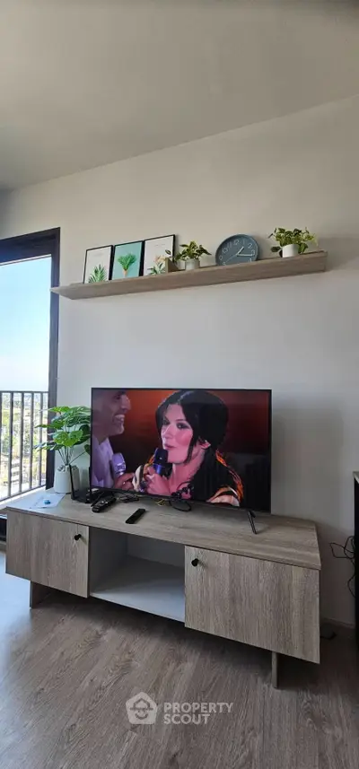 Modern living room with stylish TV stand, wall shelves, and balcony view.