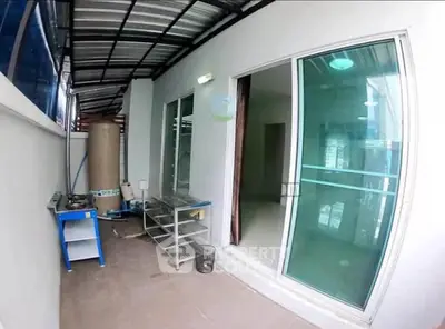 Spacious balcony with sliding glass doors and modern outdoor kitchen setup.