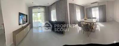 Spacious modern living room with elegant dining area and large windows.