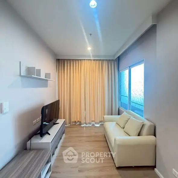 Modern living room with cozy sofa and large window, perfect for relaxation.