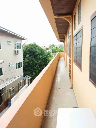 Spacious balcony with scenic view of surrounding buildings and greenery, perfect for relaxation.