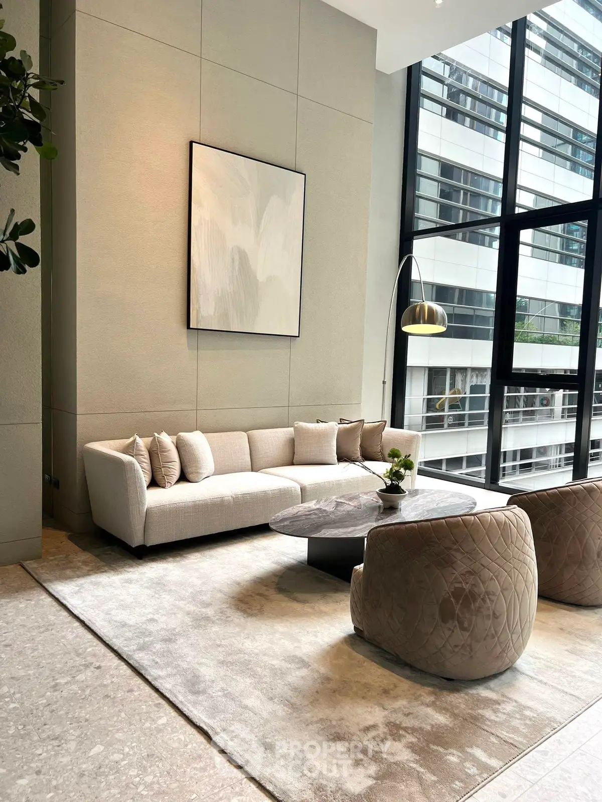 Luxurious modern living room with high ceilings and large windows in urban setting.