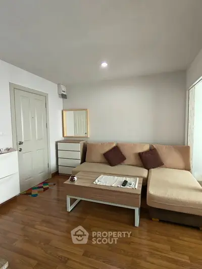 Cozy living room with modern furniture and wooden flooring, perfect for relaxation.