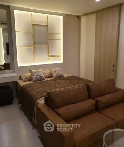 Luxurious modern bedroom with stylish lighting and cozy seating area.