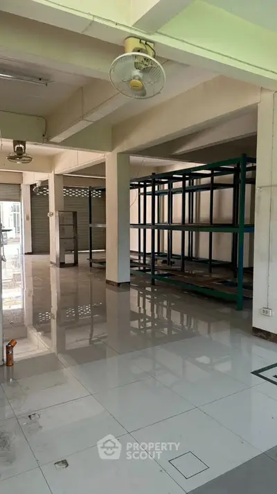 Spacious commercial space with tiled flooring and metal shelving units