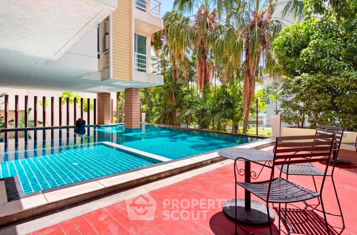 Luxurious poolside area with lush greenery and modern architecture, perfect for relaxation and leisure.