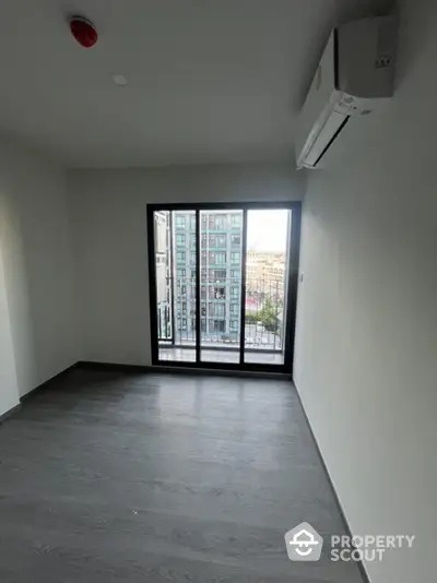 Modern empty room with large window and air conditioning in urban apartment