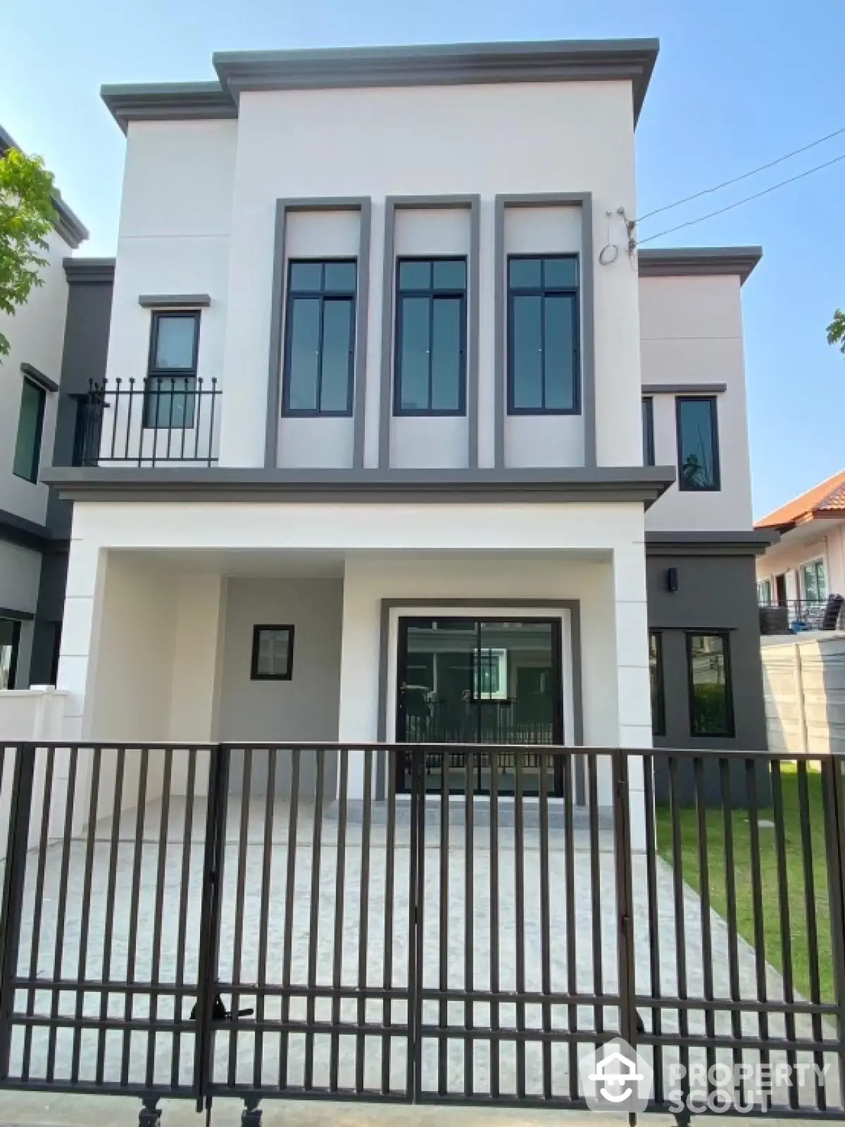 Modern two-story house with sleek facade and gated driveway