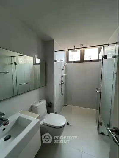Modern bathroom with glass shower enclosure and sleek fixtures