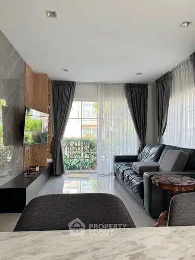 Modern living room with sleek design, large windows, and elegant furnishings.