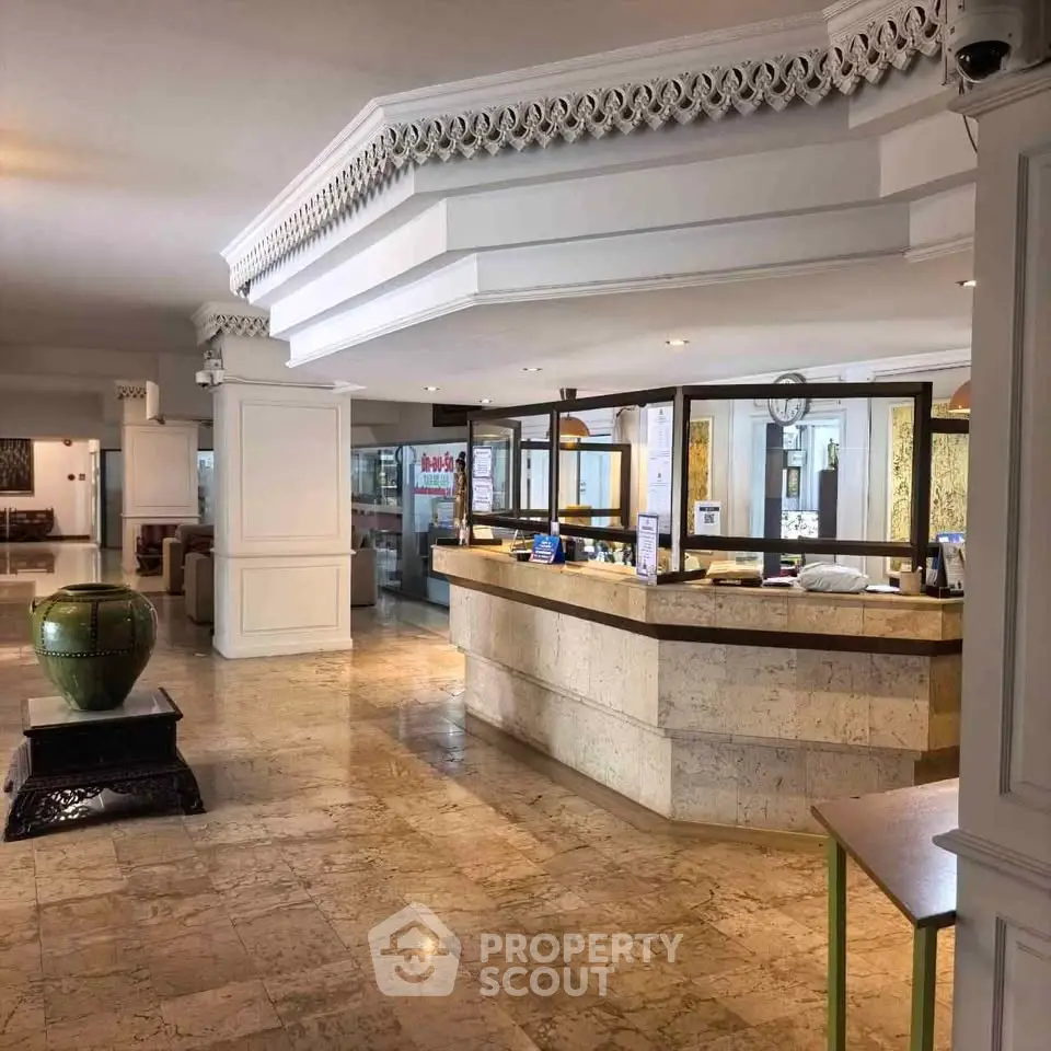 Elegant hotel lobby with marble floors and stylish reception desk, showcasing luxurious interior design.
