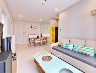 Modern living room with stylish decor and open layout, featuring a cozy sofa and dining area.
