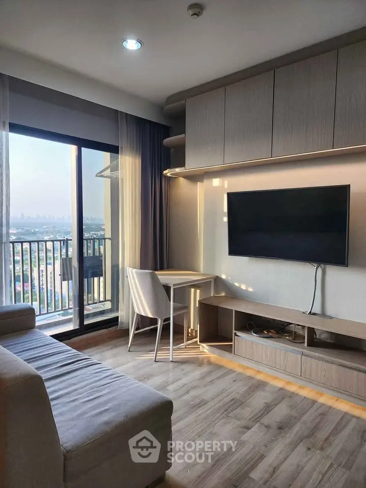 Modern living room with large window and city view, featuring sleek furniture and stylish decor.