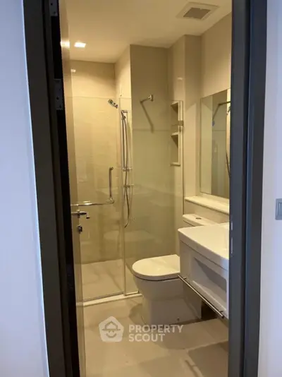 Modern bathroom with glass shower and sleek fixtures in contemporary apartment