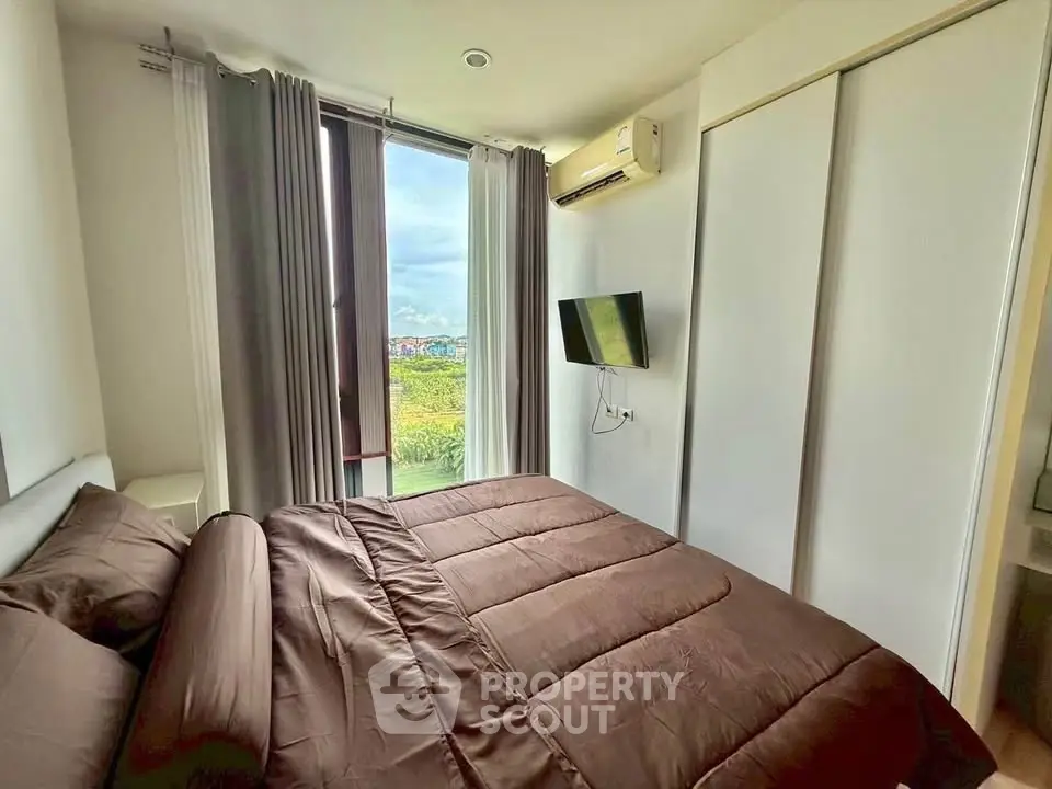 Modern bedroom with large window and scenic view, featuring sleek design and cozy bedding.