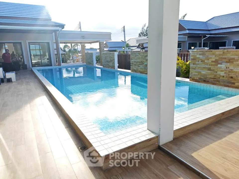 Luxurious modern home with a stunning outdoor pool and elegant patio area, perfect for relaxation and entertainment.
