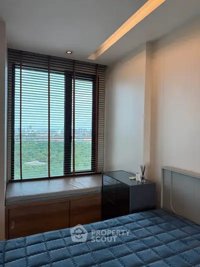 Modern bedroom with large window offering stunning city and park views, featuring sleek blinds and cozy bedding.