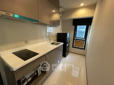 Modern compact kitchen with sleek cabinetry and induction cooktop