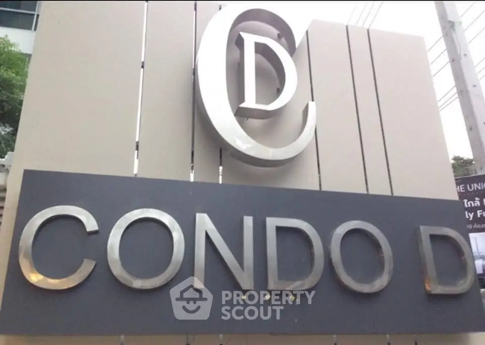 Modern condo entrance sign with sleek design and prominent logo.