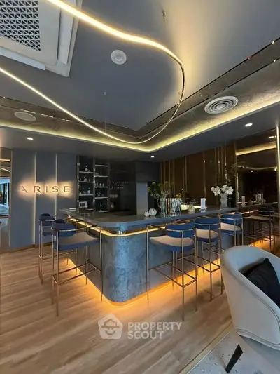Luxurious modern kitchen with sleek bar seating and ambient lighting in upscale apartment.