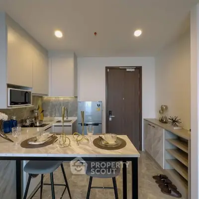 Modern kitchen with sleek design, featuring marble countertops and stylish bar seating.
