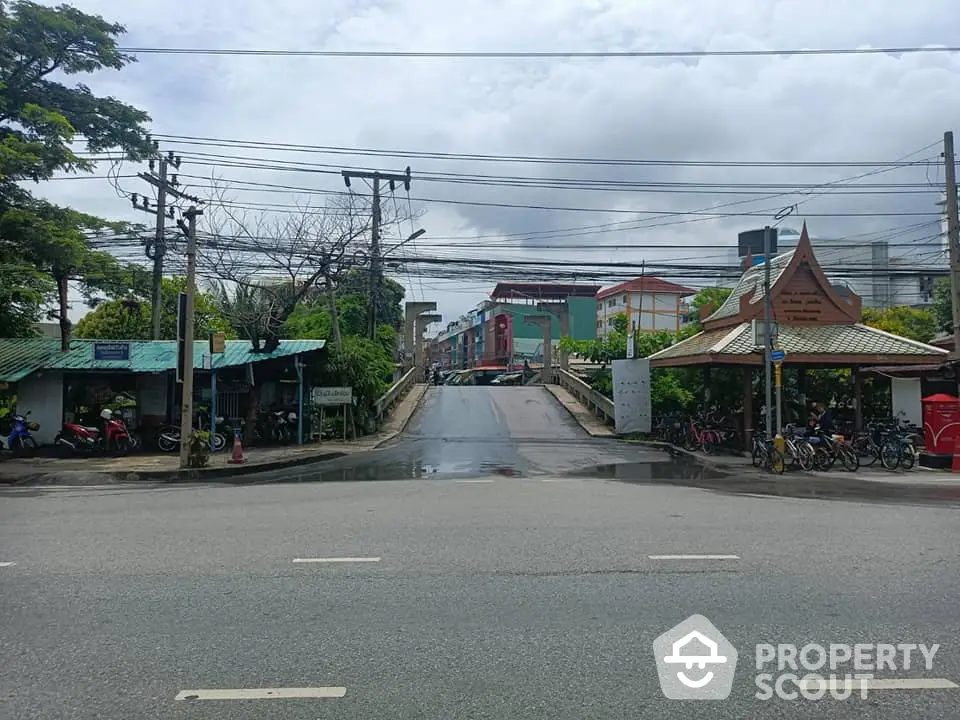 Urban street view with buildings and greenery, showcasing city infrastructure.