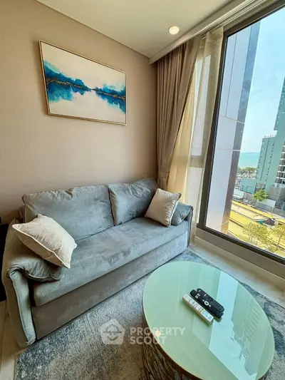 Modern living room with cozy sofa and large window offering city view