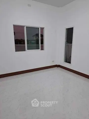 Spacious empty room with large windows and elegant flooring, perfect for customization.