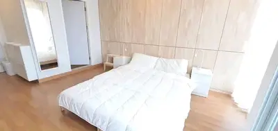 Spacious modern bedroom with minimalist design and wooden flooring