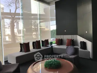 Modern living room with stylish seating and large windows offering city views.