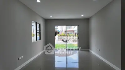 Spacious unfurnished room with large window and sliding glass door leading to outdoor view.