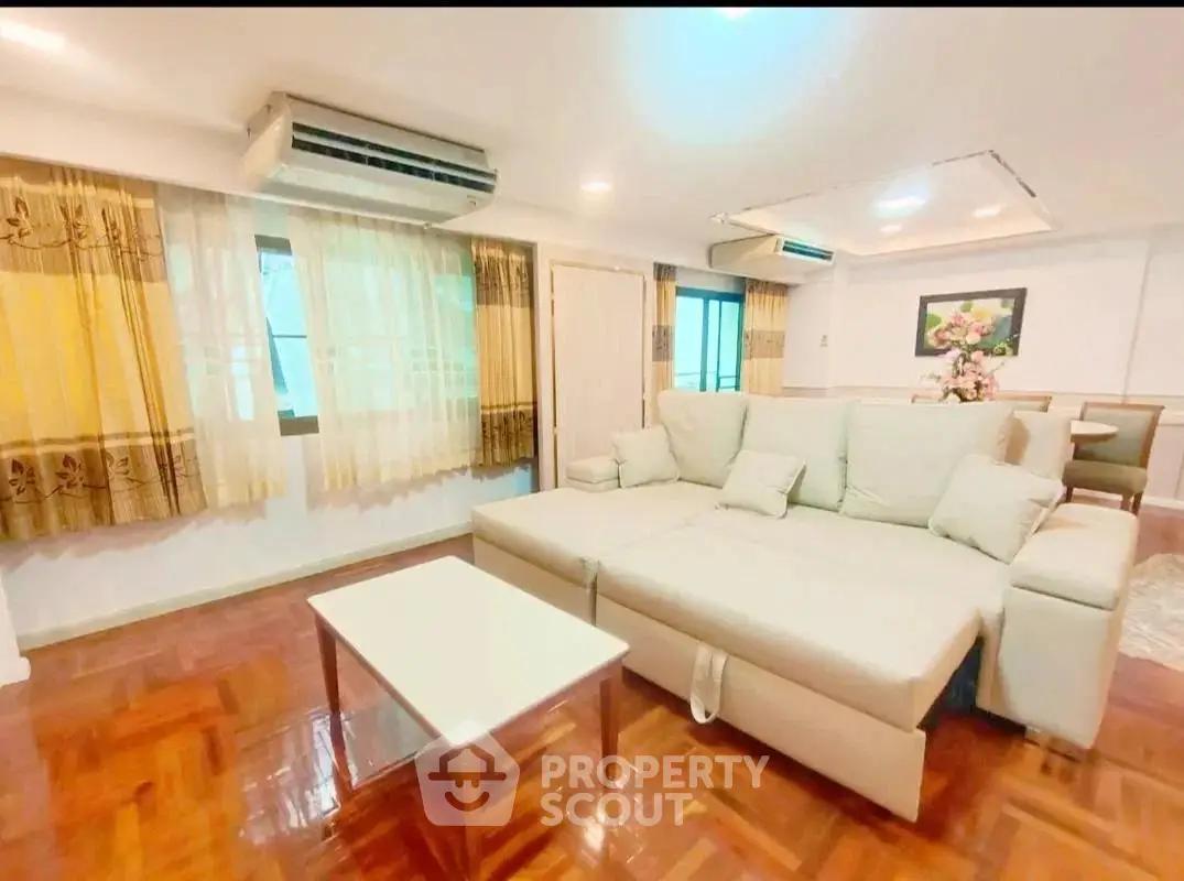 Spacious living room with elegant parquet flooring and cozy sectional sofa