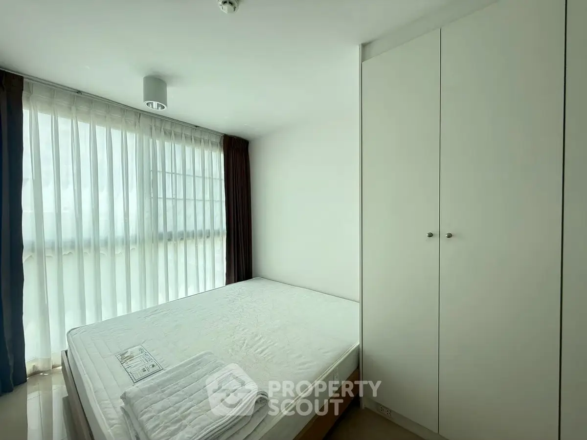 Bright and airy bedroom with large window and built-in wardrobe, perfect for a cozy retreat.