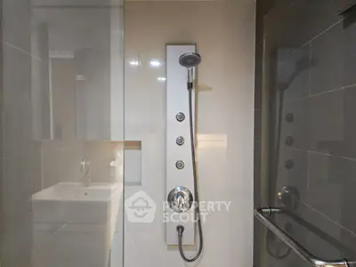 Modern bathroom with sleek shower panel and glass enclosure