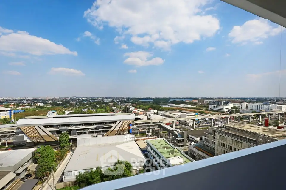 Stunning panoramic city view from high-rise balcony with clear blue sky.