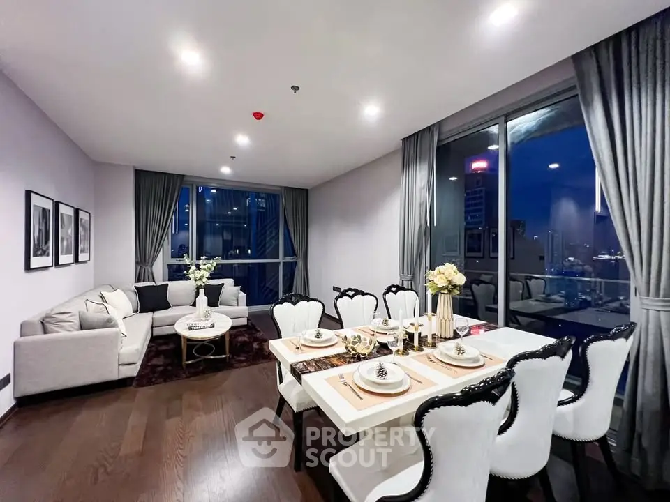 Luxurious open-plan living and dining area with elegant decor and city view.