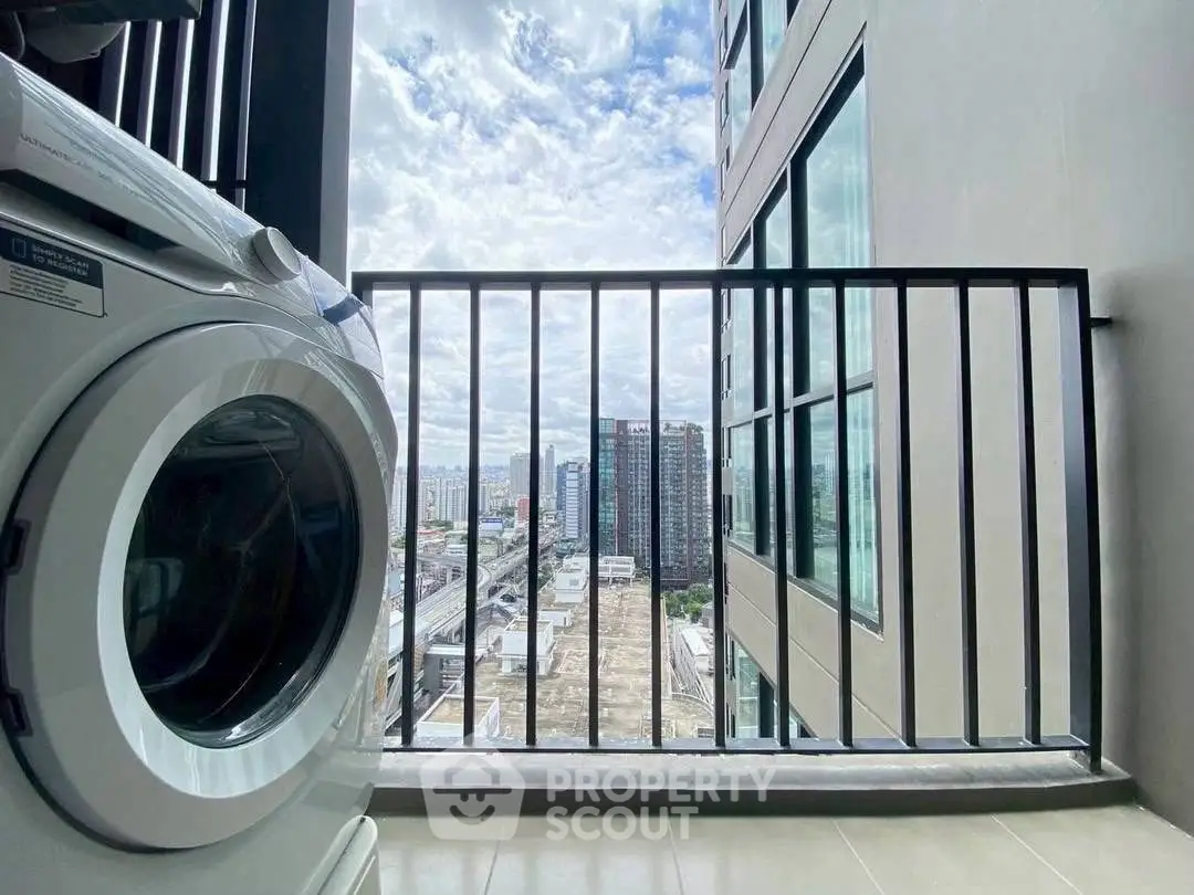 Modern apartment balcony with washing machine and city view, perfect for urban living.