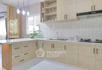 Modern kitchen with sleek cabinetry and gas stove in a bright, airy home.