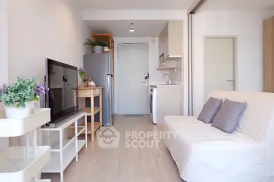 Modern open-plan living room with kitchen, featuring sleek design and cozy ambiance.