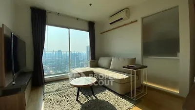 Modern living room with city view, featuring a cozy sofa and large window for natural light.