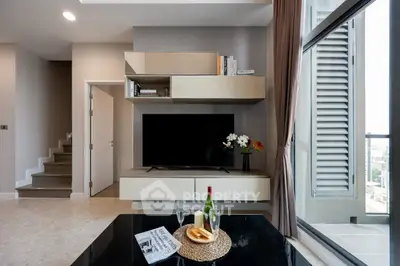 Modern living room with sleek TV unit and balcony view