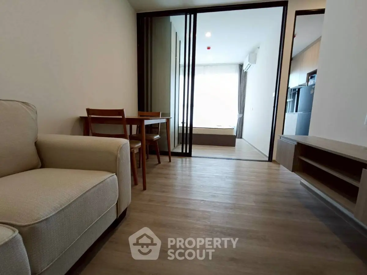 Modern living room with wooden flooring and cozy furniture in a stylish apartment.