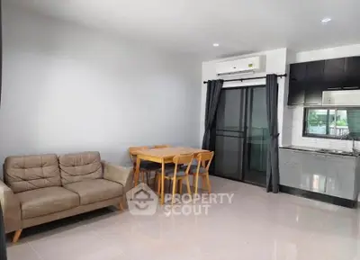Modern living room with cozy sofa and dining area in open layout apartment.