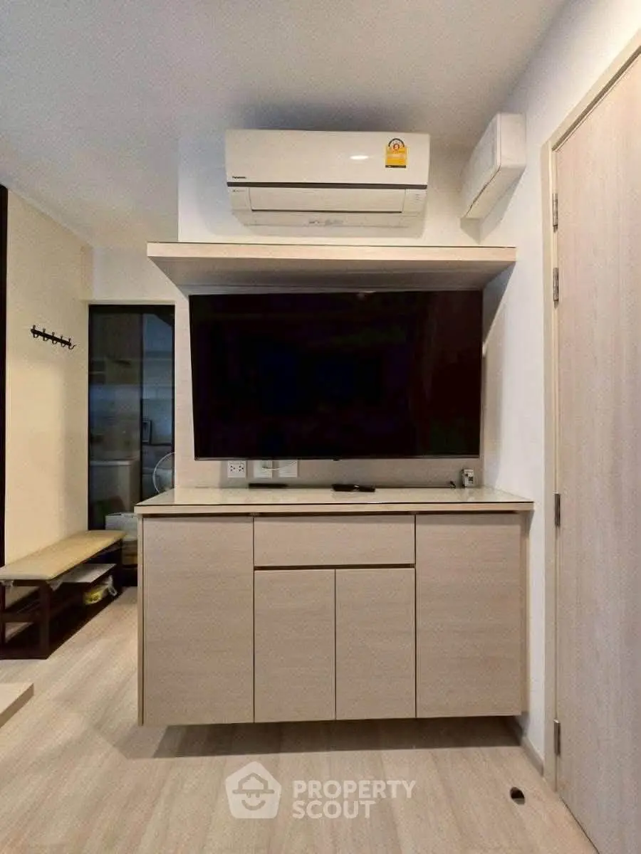 Modern living room with sleek TV cabinet and air conditioning unit, perfect for comfortable urban living.