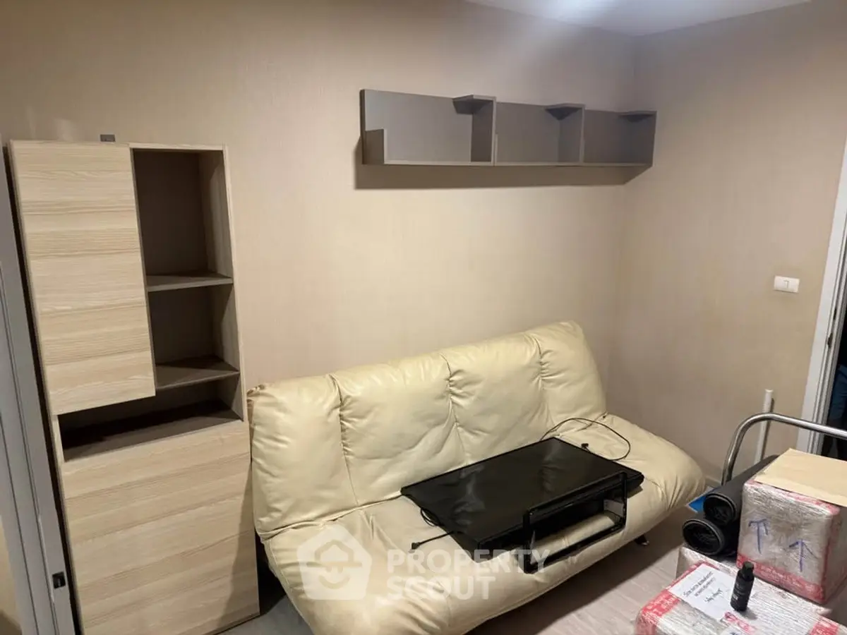 Cozy living room with beige sofa and modern shelving unit, perfect for small apartments.