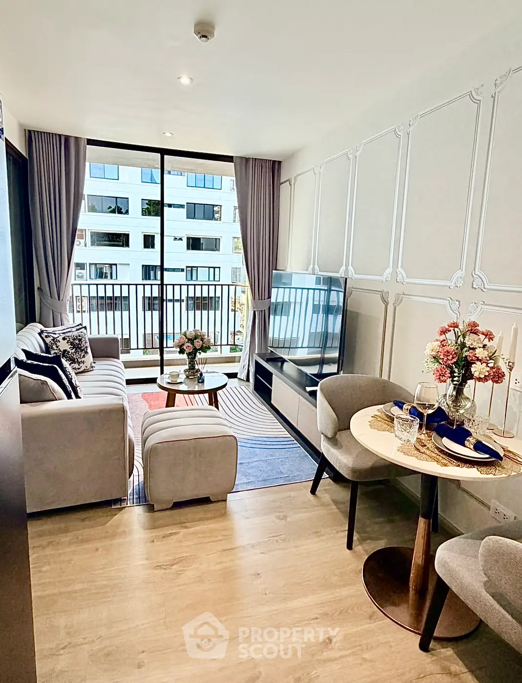 Modern living room with elegant decor and large windows offering city views