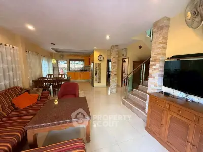 Spacious living room with modern decor and open layout, featuring a cozy seating area and dining space.