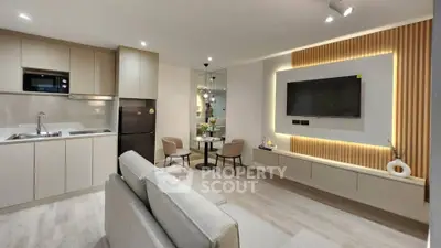 Modern open-plan living room and kitchen with sleek design and ambient lighting.