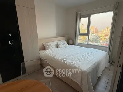 Cozy bedroom with city view, featuring a comfortable bed and modern decor.